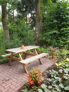 a wooden picnic table sitting on a brick patio at Apartment Heideland in Buchholz in der Nordheide