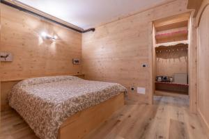 een slaapkamer met een bed en een houten muur bij Cesa Palue in Rocca Pietore