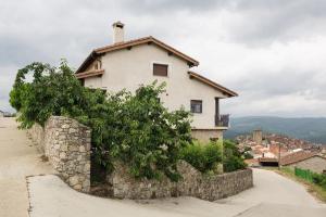 a house on a hill with a stone wall at Casa Rural Laura in Miranda del Castañar