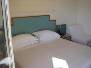 una camera con un letto con due cuscini bianchi di Hotel Belvedere a Portovenere