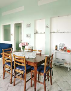 une table à manger avec des chaises et un vase de fleurs. dans l'établissement Casa Consy, à Sorrente