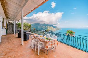 un tavolo e sedie su un balcone con vista sull'oceano di Loggetta19 a Ravello