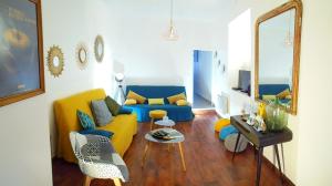 sala de estar con sofá amarillo y azul en Gîte de la Coussotterie Sud Vendée 4 **** 8 pers en Sainte-Gemme-la-Plaine