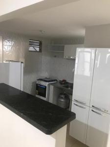 a white kitchen with a stove and a refrigerator at Ed. Oliveiro Lucena in João Pessoa