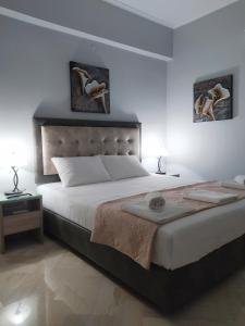 a bedroom with a large bed with two pictures on the wall at Christina's House in Parga