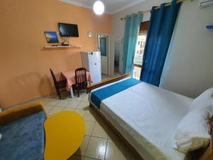 a bedroom with a bed and a table and a television at My Apartments Durres in Durrës