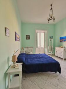 - une chambre avec un lit bleu et une table dans l'établissement Casa Consy, à Sorrente