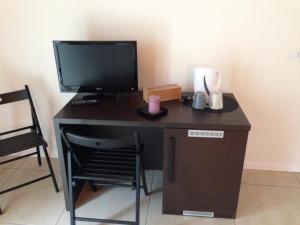 einen Schreibtisch mit einem Computer, einem Monitor und einem Stuhl in der Unterkunft Casa di Giulia in Verona