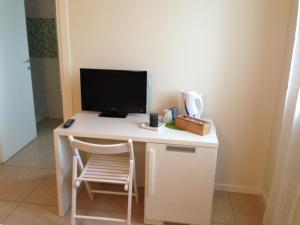 einen weißen Schreibtisch mit einem Computermonitor und einem Stuhl in der Unterkunft Casa di Giulia in Verona