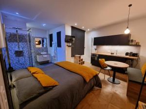a bedroom with a bed and a table and a kitchen at La chambre des secrets in Biarritz