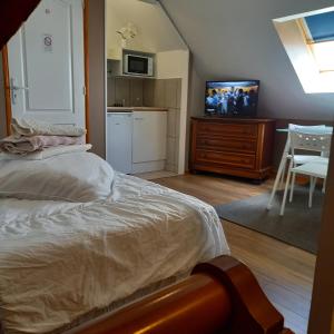 a bedroom with a bed and a tv and a kitchen at Appartement Houlet in Till&eacute;