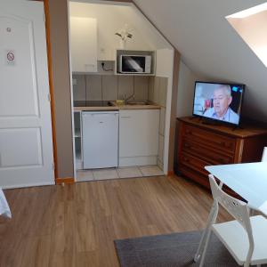 a living room with a tv and a kitchen at Appartement Houlet in Tillé