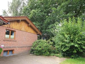 a brick house with a tree in front of it at Apartment Heideland in Buchholz in der Nordheide