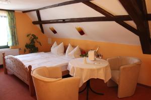 a bedroom with a bed and a table and chairs at Gasthof Hertigswalde in Sebnitz