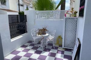 un balcon avec une table et des chaises sur un sol en damier dans l'établissement STUDIO -PATIO ANDALUZ-, à Marbella
