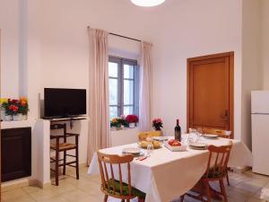 a dining room with a table with chairs and a television at Monte Astili in Lanusei