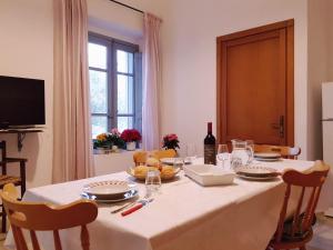a dining room table with a white table cloth and chairs at Monte Astili in Lanusei +28 photos
