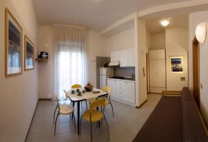 een keuken en eetkamer met een tafel en stoelen bij Residence Caterina in Cattolica