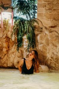 a woman is sitting in the water in a swimming pool at Pietraluna luxury b&b in Giovinazzo