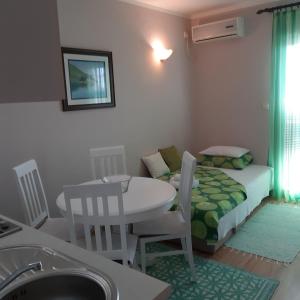 a small room with a table and a bed at Apartmani Beljkas in Tivat