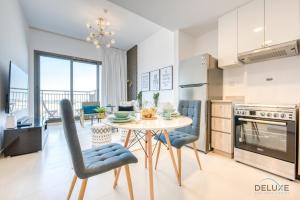 a kitchen and dining room with a table and chairs at Charismatic 1BR at UNA Town Square Dubailand by Deluxe Holiday Homes in Dubai