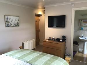 a bedroom with a bed and a tv on the wall at Yorecroft in Aysgarth
