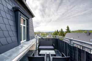 a balcony with chairs and a table on a house at Ferienwohnung LOFT STUDIO ANNABERG in Annaberg-Buchholz