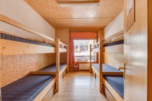 Zimmer mit 3 Etagenbetten und einem Fenster in der Unterkunft Les Louerettes in Siviez