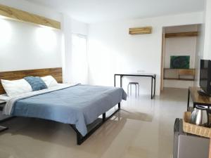 a bedroom with a large bed and a table at Purple Orchid Bed and Breakfast in Tagaytay