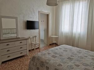 a bedroom with a bed and a dresser and a television at Il Colibrì Bed&Breakfast in Leno