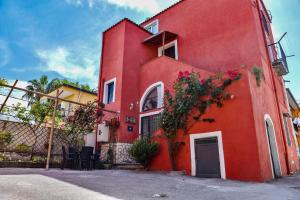 un edificio rosso con dei fiori sul lato di Domus Carolina a Pompei