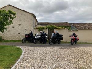 un grupo de motocicletas estacionadas frente a un edificio en La Ferme Buissonnière, en Bardou