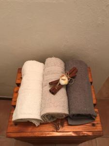 a wooden tray with towels and a cross and cinnamon at LA CASA DI ZOE in Campiglia Marittima