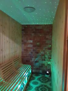 a room with a sauna with a brick wall at Rózsapark Vendégház in Demjén