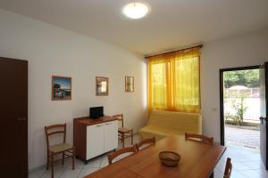a living room with a table and a room with a bed at Acquasmeralda appartamento 03 in Rosolina Mare