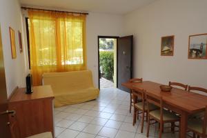 uma sala de estar com uma mesa de madeira e um sofá em Acquasmeralda appartamento 03 em Rosolina Mare