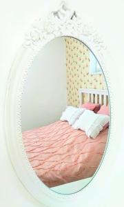 a white mirror with a bed in a bedroom at Romantic Style Apartment Titisee-Neustadt in Titisee-Neustadt