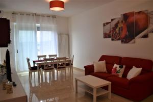 ein Wohnzimmer mit einem roten Sofa und einem Tisch in der Unterkunft Melograno Home in Neapel