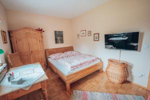 Schlafzimmer mit einem Bett, einem Tisch und einem TV in der Unterkunft Gästewohnung Sebastian in Grundlsee