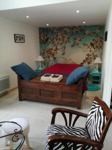 ein Schlafzimmer mit einem großen Holzbett mit blauen Kissen in der Unterkunft Atelier aux Dimes in Le Manoir