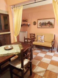 sala de estar con mesa, sillas y sofá en Casa vacanza Il Giardino, en Supersano