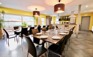 una sala da pranzo con un lungo tavolo e sedie di La Villa Roannaise a Stoumont