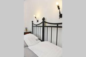 a bedroom with a black bed with white sheets at Atropos Varvara in Posidhonía