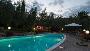 a swimming pool in a yard with an umbrella at Villa Tara Gaeta in Gaeta