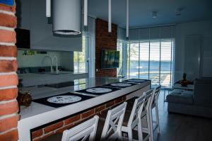 a kitchen with a counter with a stove and chairs at nautica lux apartamenty in Giżycko