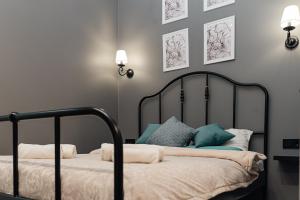 a bedroom with a black metal bed with pillows at Romantika Smolny appartment in Saint Petersburg