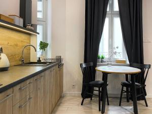 a kitchen with a table and chairs and a window at Beautiful studio for couples - Old Town & Main station in Krakow