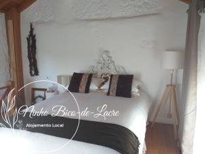 a bedroom with a bed with a white bediboiboibo lodge sign on it at Ninho Bico-de-Lacre ~ o paraíso é a/na Terra in Balocas