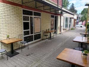 a patio with tables and chairs outside of a building at Wanted Šabac apartman in Šabac