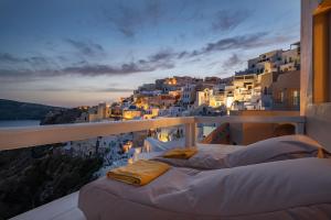 un balcón con camas en el lateral de un edificio en Armeni Luxury Villas, en Oia